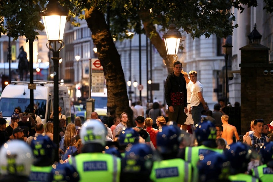 Police officers stand guard during a protest against illegal immigration, in London Britain, July 31, 2024. REUTERS/Hollie Adams