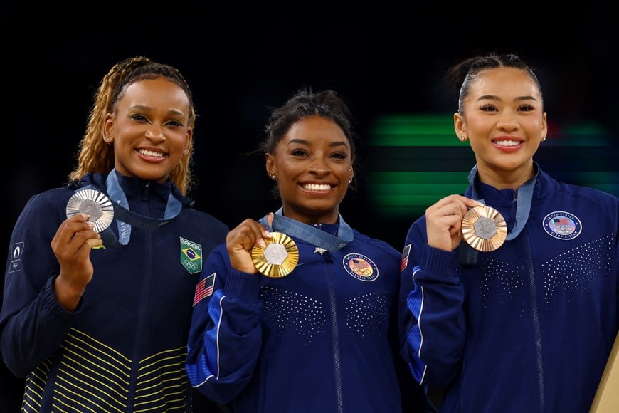 Paris 2024 Olympics - Artistic Gymnastics - Women's All-Around Victory Ceremony - Bercy Arena, Paris, France - August 01, 2024.
Gold medallist Simone Biles of United States celebrates on the podium with silver medallist Rebeca Andrade of Brazil and bronze medallist Sunisa Lee of United States. REUTERS/Hannah Mckay
