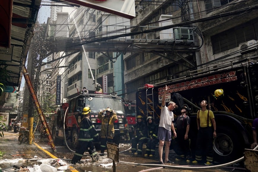 Firemen extinguish a fire at a building in Manila, Philippines, August 2, 2024. REUTERS/Lisa Marie David