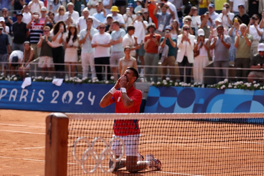 Paris 2024 Olympics - Tennis - Men's Singles Gold Medal Match - Roland-Garros Stadium, Paris, France - August 04, 2024.
Novak Djokovic of Serbia celebrates after winning gold against Carlos Alcaraz of Spain. REUTERS/Claudia Greco