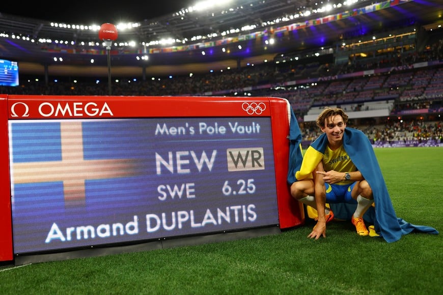 Paris 2024 Olympics - Athletics - Men's Pole Vault Final - Stade de France, Saint-Denis, France - August 05, 2024.
Armand Duplantis of Sweden celebrates alongside a time board after winning gold and establishing a world record. REUTERS/Kai Pfaffenbach