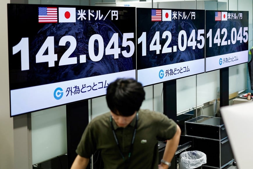 An employee of the foreign exchange trading company Gaitame.com walks past monitors displaying the Japanese yen exchange rate against the U.S. dollar in Tokyo, Japan, August 5, 2024. REUTERS/Willy Kurniawan