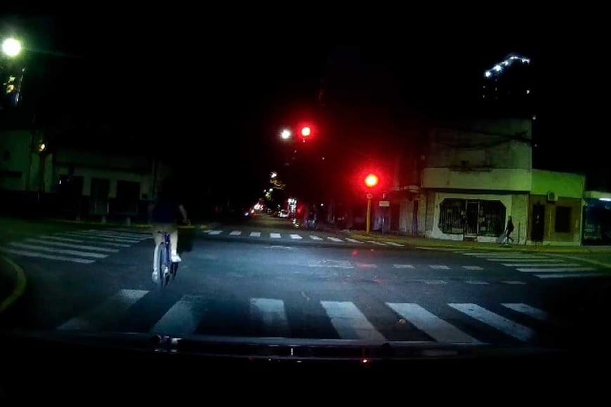 Sin luz y en rojo. Un ciclista atraviesa Urquiza en un momento vedado por el semáforo.