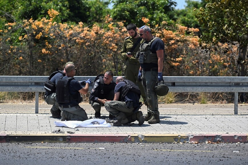 Israeli police and a soldier work at the impact site of a projectile, after Lebanon's armed group Hezbollah said it launched a swarm of attack drones against military targets in northern Israel, in Nahariya, Israel, August 6, 2024. REUTERS/Rami Shlush    ISRAEL OUT. NO COMMERCIAL OR EDITORIAL SALES IN ISRAEL