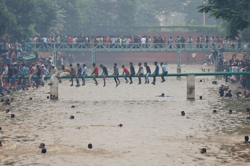 People swim in the lake inside Ganabhaban, the Prime Minister's residence, after the resignation of the Sheikh Hasina in Dhaka, Bangladesh, August 5, 2024. REUTERS/Mohammad Ponir Hossain     TPX IMAGES OF THE DAY