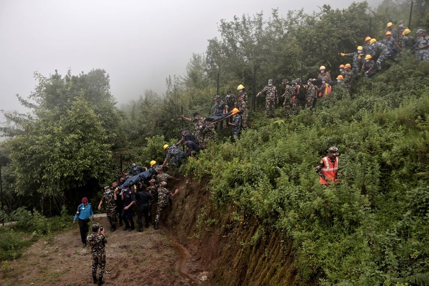 Security force personnel carry bodies of victims at the site of a helicopter crash on the outskirts of Kathmandu, Nepal, August 7, 2024. REUTERS/Navesh Chitrakar