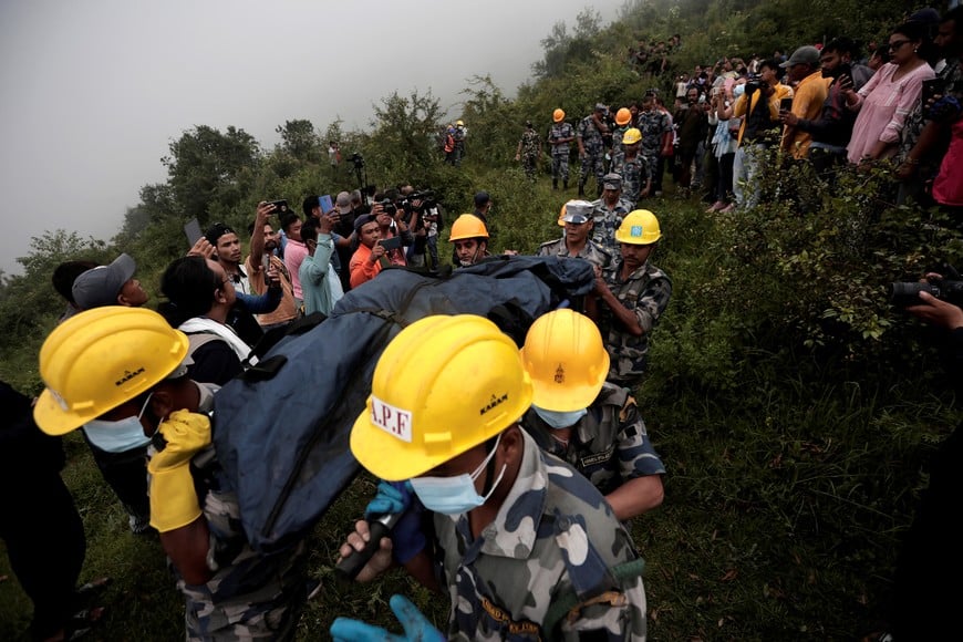 Security force personnel carry the body of a victim at the site of a helicopter crash on the outskirts of Kathmandu, Nepal, August 7, 2024. REUTERS/Navesh Chitrakar