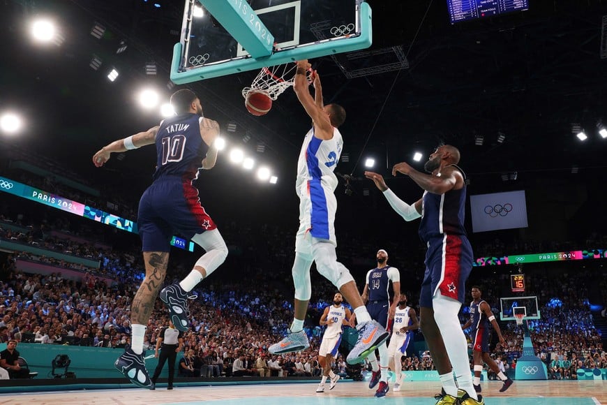 Paris 2024 Olympics - Basketball - Men's Gold Medal Game - France vs United States - Bercy Arena, Paris, France - August 10, 2024.
Rudy Gobert of France in action with Jayson Tatum of United States and Lebron James of United States. REUTERS/Brian Snyder