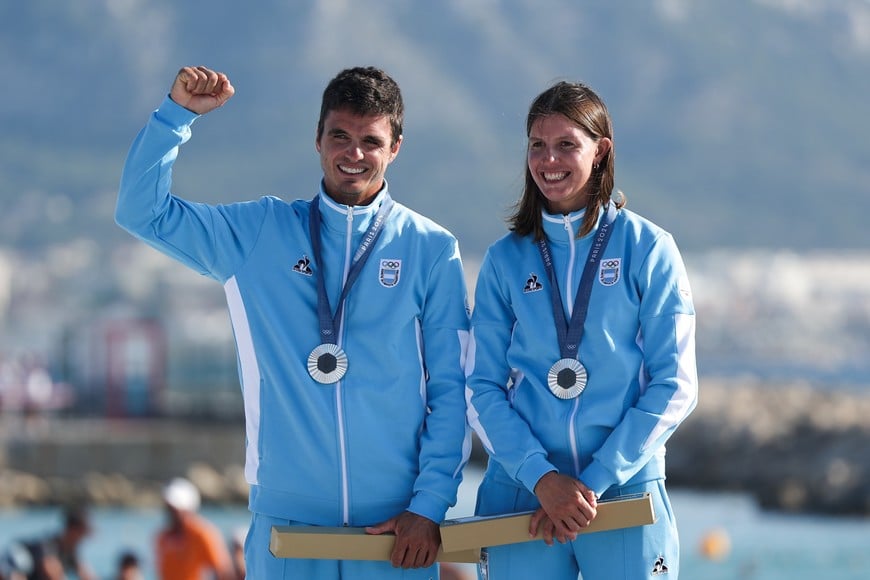 (240808) -- MARSELLA, 8 agosto, 2024 (Xinhua) -- Los medallistas de plata Mateo Majdalani (i) y Eugenia Bosco de Argentina reaccionan durante la ceremonia de victoria de multicasco mixto de los eventos de vela de los Juegos Olímpicos de París 2024 en la Marina de Marsella, en Marsella, Francia, el 8 de agosto de 2024. (Xinhua/Zheng Huansong) (ra) (ah)