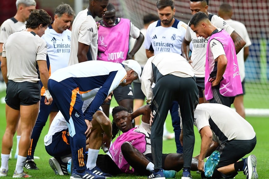 Soccer Football - UEFA Super Cup - Real Madrid Training - National Stadium, Warsaw, Poland - August 13, 2024
Real Madrid's Eduardo Camavinga receives medical attention after sustaining an injury as coach Carlo Ancelotti and teammates look on during training REUTERS/Jennifer Lorenzini