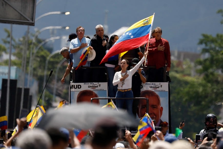 Venezuelan opposition leader Maria Corina Machado holds up a Venezuelan flag during a march amid the disputed presidential election, in Caracas, Venezuela, August 17, 2024. REUTERS/Leonardo Fernandez Viloria