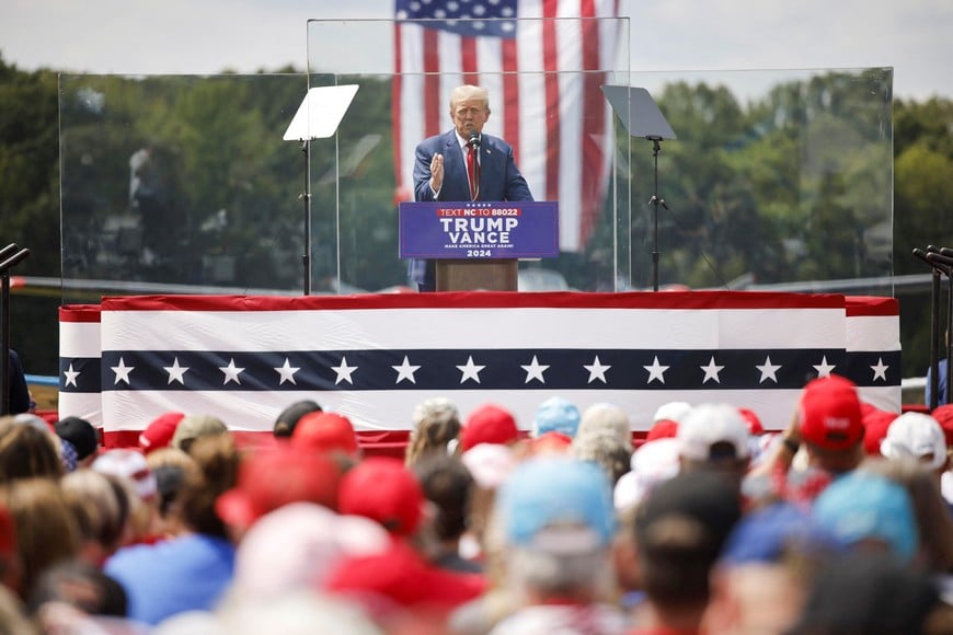 Republican presidential nominee and former U.S. President Donald Trump speaks from a bulletproof glass housing during a campaign rally, at the North Carolina Aviation Museum & Hall of Fame in Asheboro, North Carolina, U.S. August 21, 2024. REUTERS/Jonathan Drake