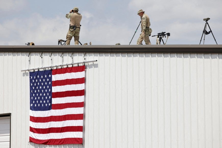 Security forces members keep watch on the day of a campaign rally held by former U.S. President Donald Trump at Asheboro Regional Airport in Asheboro, North Carolina, U.S. August 21, 2024. REUTERS/Jonathan Drake
     TPX IMAGES OF THE DAY