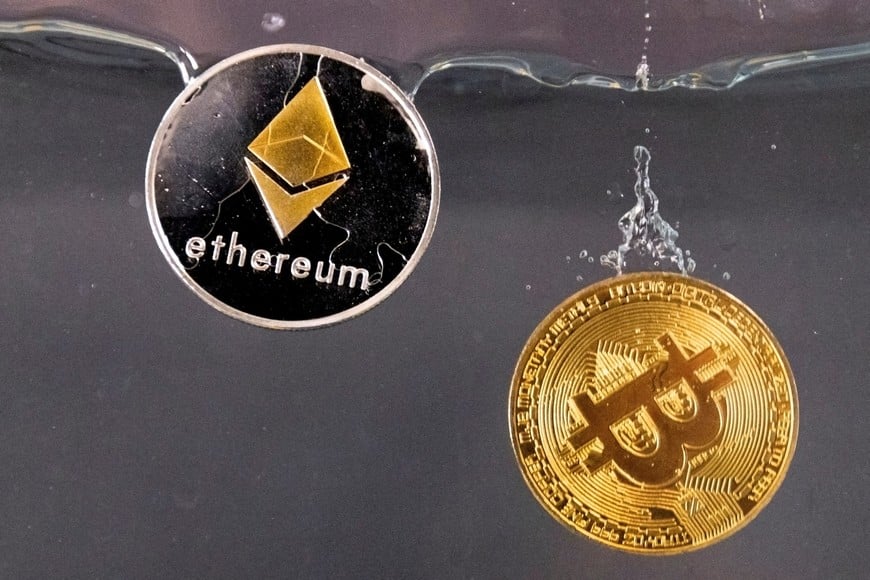 FILE PHOTO: Tokens representing cryptocurrencies bitcoin and ether plunge into water in this illustration taken May 17, 2022. REUTERS/Dado Ruvic/File Photo