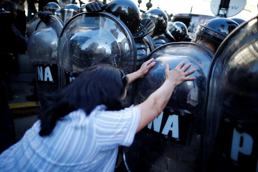 A demonstrator clashes with a police officer outside the National Congress during a protest against Argentina President Javier Milei's decision to veto a pension reform, outside the National Congress, in Buenos Aires, Argentina, September 4, 2024. REUTERS/Agustin Marcarian