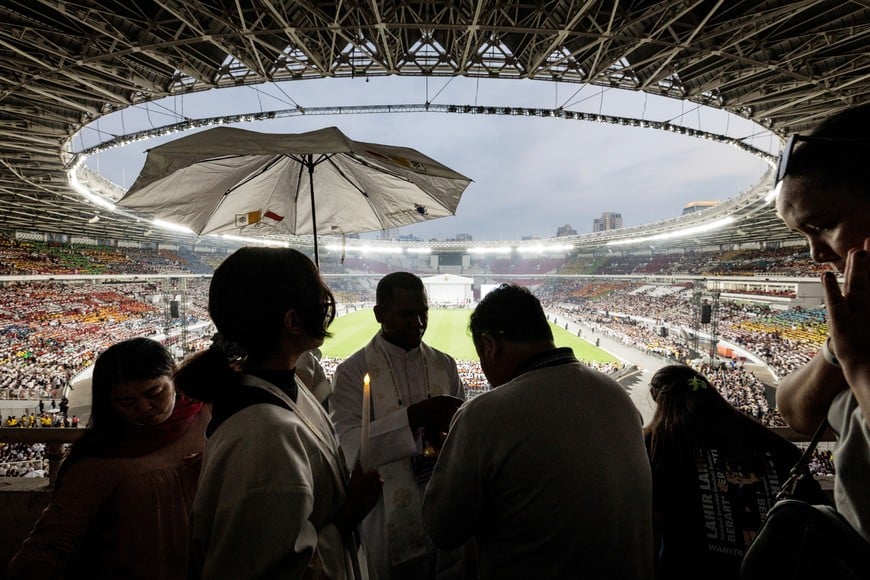 A priest gives Holy Communion to the faithful during a holy mass led by Pope Francis at the Gelora Bung Karno Stadium in Jakarta on September 5, 2024. YASUYOSHI CHIBA/Pool via REUTERS