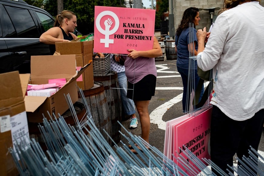 People pick up signs in support of U.S. Vice President and Democratic presidential nominee Kamala Harris during a lawn sign distribution event at Batch Brewery in Detroit, Michigan, U.S. September 5, 2024. REUTERS/Emily Elconin