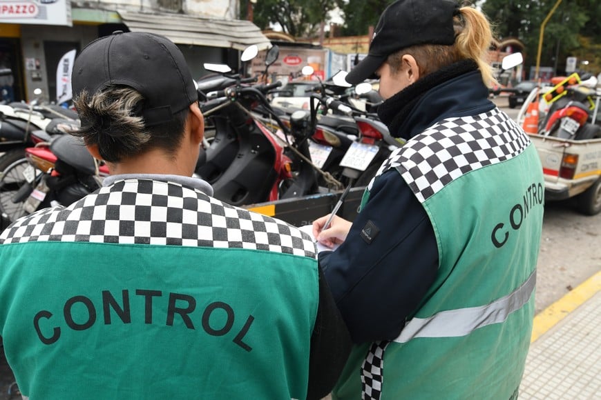 Dos inspectores municipales durante un procedimiento de retención de motos detectadas en infracción. La falta de uso de casco, la falta más grave.