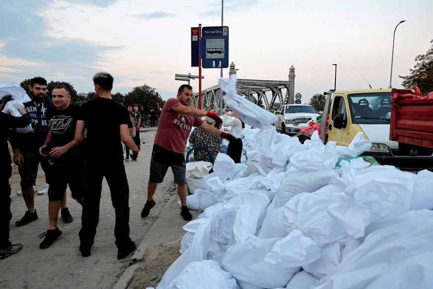 A man throws a sandbag, as preparations against flooding continue at the banks of the Oder river, near Piastowski bridge, in Brzeg, Poland, September 18, 2024. Agencja Wyborcza.pl/Patryk Ogorzalek via REUTERS   ATTENTION EDITORS - THIS IMAGE WAS PROVIDED BY A THIRD PARTY. POLAND OUT. NO COMMERCIAL OR EDITORIAL SALES IN POLAND.