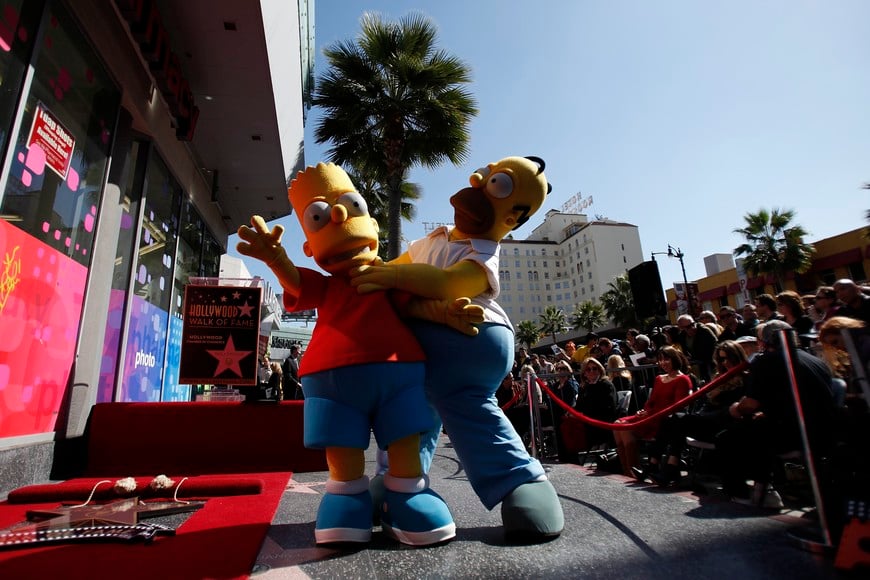 The characters of Homer (R) and Bart Simpson pose by the star of Matt Groening, creator of "The Simpsons," before it was unveiled on the Walk of Fame in Hollywood, California February 14, 2012.  REUTERS/Mario Anzuoni (UNITED STATES - Tags: ENTERTAINMENT) eeuu hollywood  creador de los simpsons recibe una estrella en el paseo de la fama homero y bart simpson