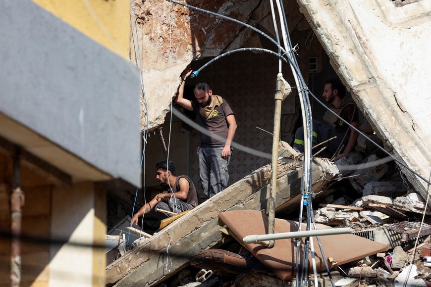 People look at the damage at the site of an Israeli strike in Beirut's southern suburbs, Lebanon September 24, 2024. REUTERS/Mohamed Azakir