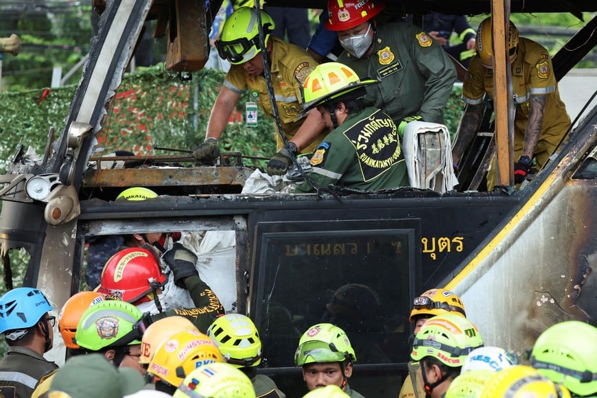 Firefighters transfer bodies from a burnt-out bus that was carrying teachers and students from Wat Khao Phraya school, which reportedly resulted in fatalities and injuries, on the outskirts of Bangkok, Thailand, October 1, 2024. REUTERS/Chalinee Thirasupa