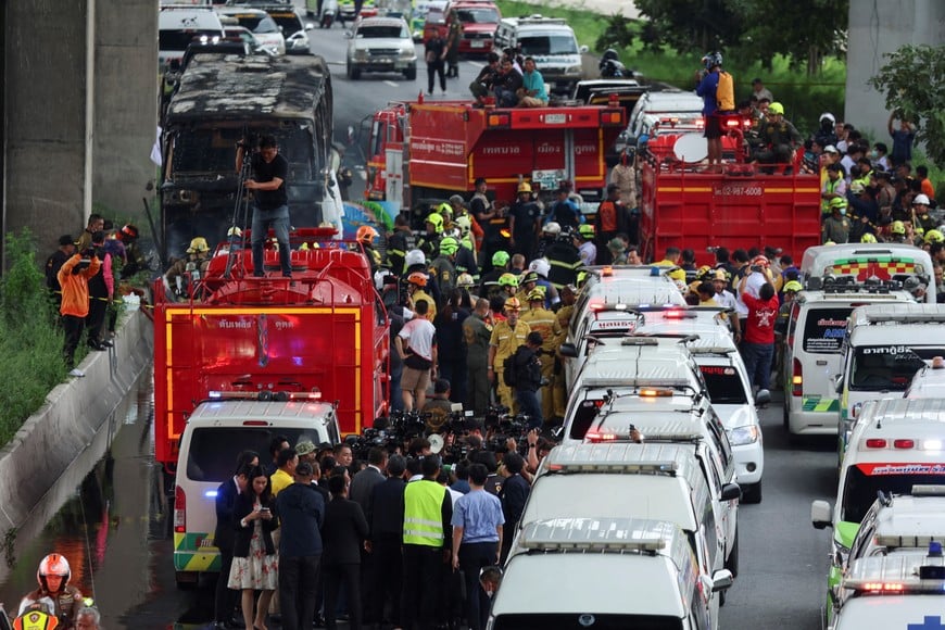 First responders work by a burnt-out bus that caught fire while carrying teachers and students from Wat Khao Phraya school, reportedly killing and injuring dozens, on the outskirts of Bangkok, Thailand, October 1, 2024. REUTERS/Chalinee Thirasupa