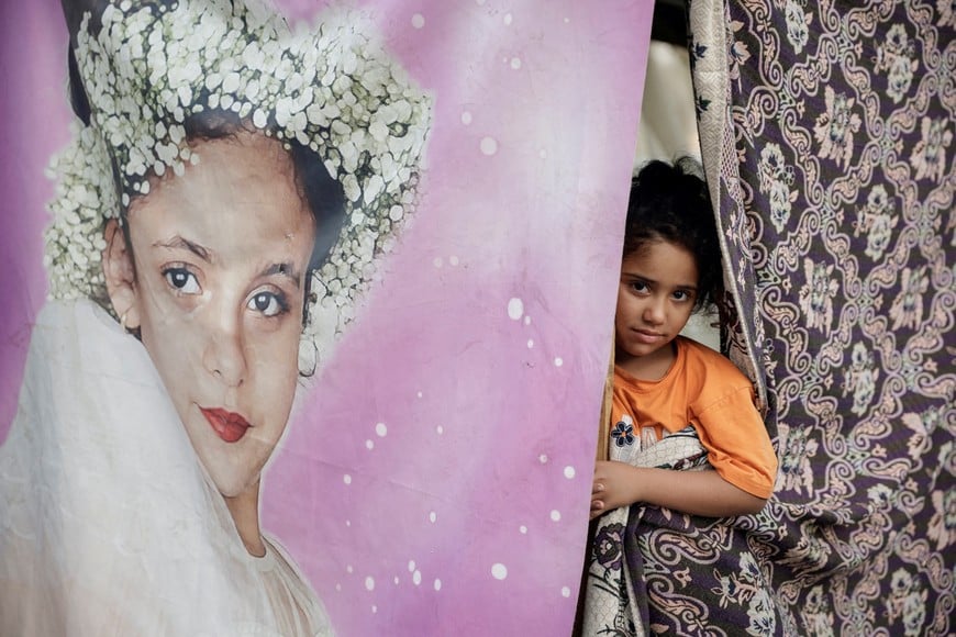 A child peers out from her family's makeshift shelter, along a seaside in western Beirut, Lebanon, October 6, 2024. REUTERS/Louisa Gouliamaki     TPX IMAGES OF THE DAY