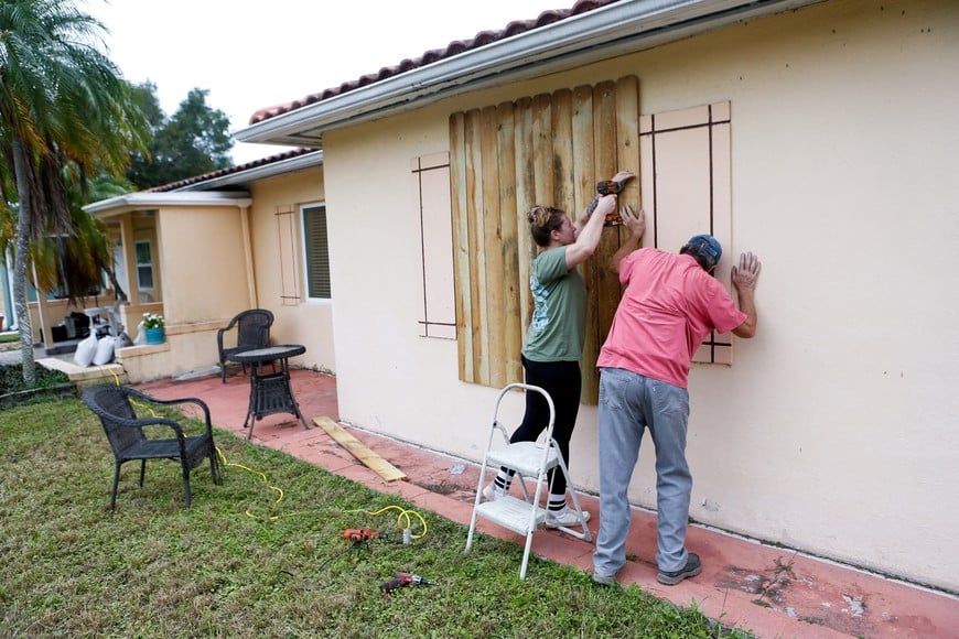 Sofia Andreeva and her uncle Ivaylo Kanchev board up their home ahead of the arrival of Hurricane Milton in St. Petersburg, Florida, U.S., October 8, 2024. REUTERS/Octavio Jones     TPX IMAGES OF THE DAY