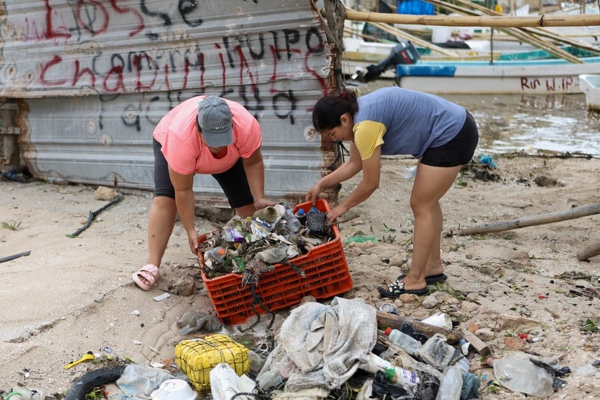 People clean up debris after Hurricane Milton brought heavy rain and flooding to Mexico's Yucatan Peninsula on its way to Florida, in Celestun, Mexico October 8, 2024. REUTERS/Lorenzo Hernandez