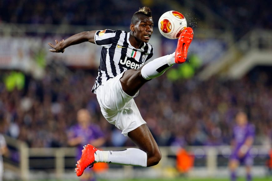 Juventus' Paul Pogba is airborne as he jumps to control the ball during their Europa League round of 16 second leg soccer match against Fiorentina at Artemio Franchi stadium in Florence March 20, 2014. REUTERS/Giampiero Sposito (ITALY - Tags: SPORT SOCCER TPX IMAGES OF THE DAY) italia florencia Paul Pogba futbol copa liga europa futbolistas fiorentina vs juventus