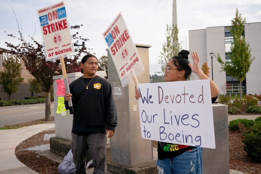 Family members of a Boeing worker hold signs at a picket line near the entrance to a Boeing production facility in Renton, Washington, U.S. October 11, 2024. REUTERS/David Ryder