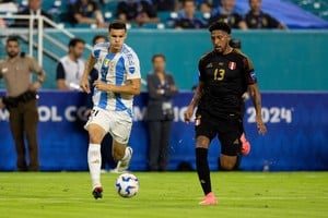 Jun 29, 2024; Miami, FL, USA;  Argentina midfielder Valentin Carboni (21) and Peru midfielder Jesus Castillo (13) battle for the ball in the second half during a Copa America group stage match at Hard Rock Stadium. Mandatory Credit: Nathan Ray Seebeck-USA TODAY Sports