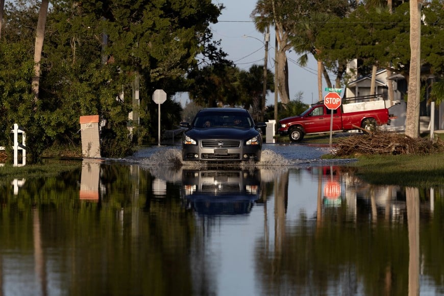 A car drives through a flooded street after Hurricane Milton made landfall in South Daytona, Florida, U.S., October 11, 2024. REUTERS/Ricardo Arduengo