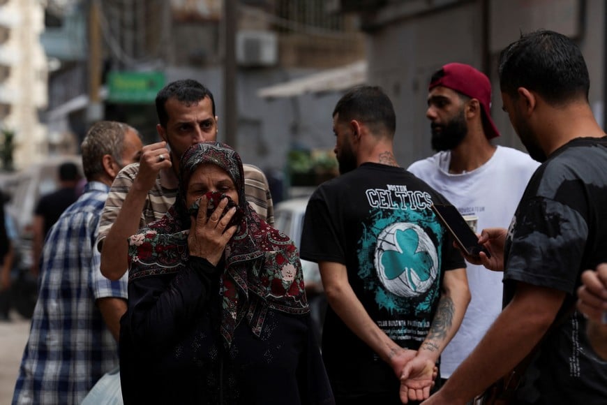 A woman covers her mouth and nose as she walks at a site of an Israeli strike, amid ongoing hostilities between Hezbollah and Israeli forces, in Beirut, Lebanon, October 12, 2024. REUTERS/Emilie Madi