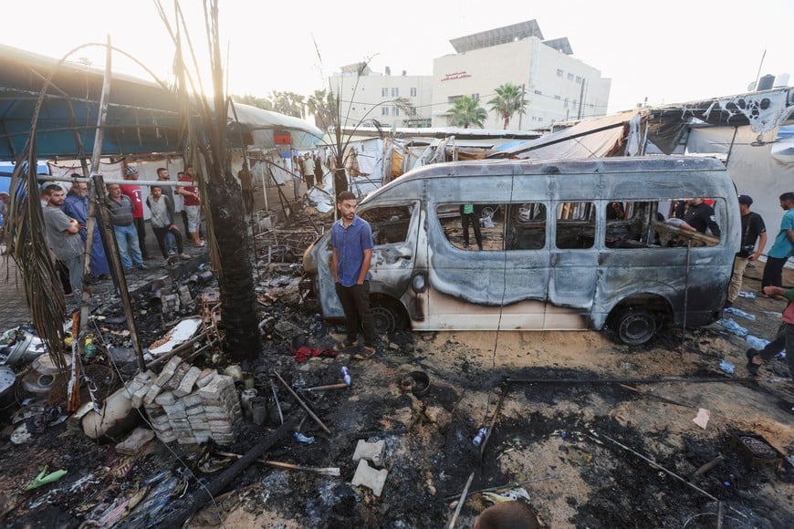 Palestinians survey the damage at the site of an Israeli strike on tents sheltering displaced people, amid the Israel-Hamas conflict, at Al-Aqsa Martyrs hospital in Deir Al-Balah in the central Gaza Strip, October 14, 2024. REUTERS/Ramadan Abed