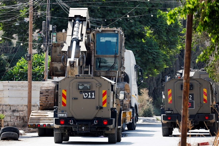 Israeli military vehicles are seen during a raid in Jenin, in the Israeli-occupied West Bank, October 14, 2024. REUTERS/Raneen Sawafta