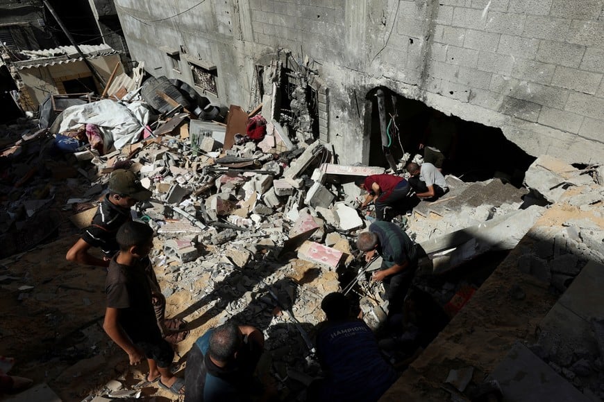 Palestinians inspect the site of an Israeli strike on a house, amid the ongoing Israel-Hamas conflict, in Al Maghazi refugee camp in the central Gaza Strip, October 19, 2024. REUTERS/Ramadan Abed