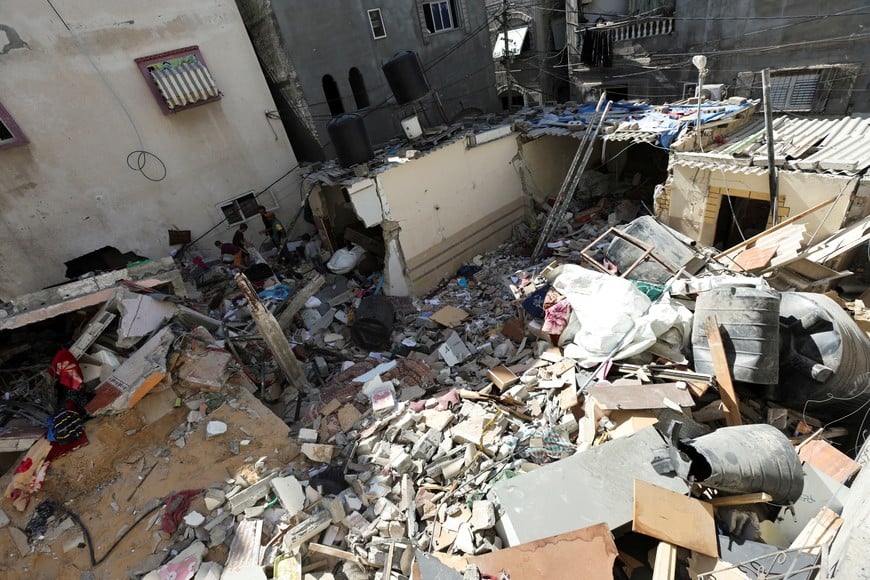 Palestinians inspect the site of an Israeli strike on a house, amid the ongoing Israel-Hamas conflict, in Al Maghazi refugee camp in the central Gaza Strip, October 19, 2024. REUTERS/Ramadan Abed