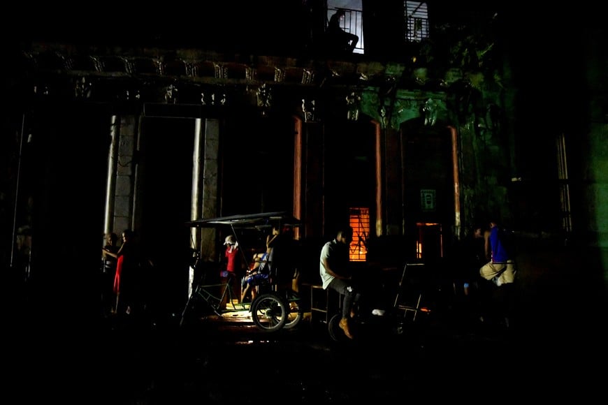 People gather in the street at night as Cuba is hit by an island-wide blackout, in Havana, Cuba, October 18, 2024. REUTERS/Norlys Perez