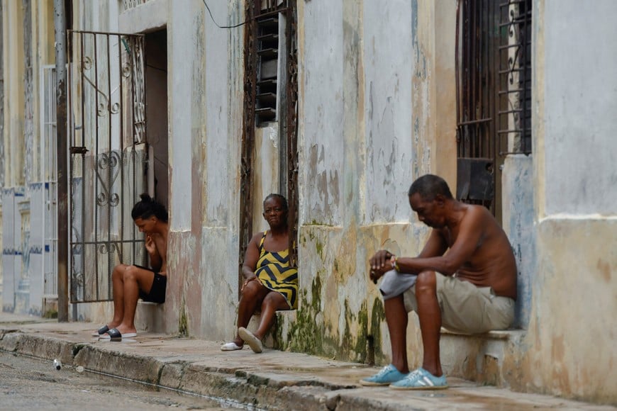 Residents sit outside their homes, after state-run media earlier on Saturday reported the national grid had collapsed for a second time in 24 hours, in Havana, Cuba October 19, 2024. REUTERS/Norlys Perez