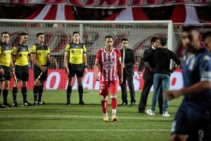 Todos los protagonistas del desenlace del partido en una sola foto. El Kily con los brazos "en jarra" mirando a Nicolás Ramírez. El árbitro parado y casi desafiante ante el entrenador. Y Corvalán, el de la mano totalmente casual e indeseada que derivó en el penal, yéndose del campo de juego. Crédito: 
Matías Pintos