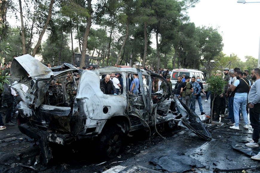 (241021) -- DAMASCO, 21 octubre, 2024 (Xinhua) -- Personas se reúnen alrededor de los restos de un vehículo alcanzado por un ataque aéreo israelí, en el barrio Mazzeh de Damasco, Siria, el 21 de octubre de 2024. Dos civiles murieron y otros tres resultaron heridos en un ataque aéreo israelí el lunes contra un vehículo civil en el oeste de la capital siria de Damasco, dijo el Ministerio de Defensa sirio. (Xinhua/Ammar Safarjalani) (rtg) (ah) (ce)