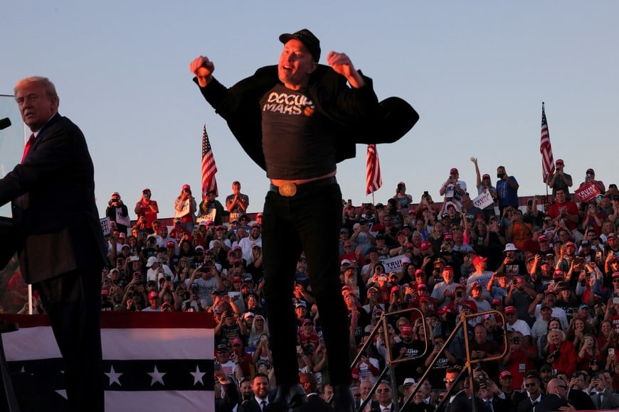 Tesla CEO and X owner Elon Musk reacts next to Republican presidential nominee and former U.S. president Donald Trump during a campaign rally, at the site of the July assassination attempt against Trump, in Butler, Pennsylvania, U.S., October 5, 2024. REUTERS/Brian Snyder