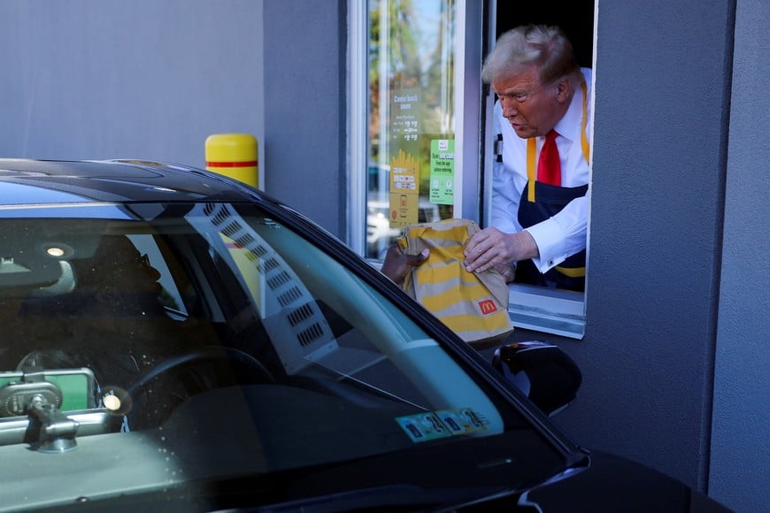 Republican presidential nominee and former U.S. President Donald Trump serves food at a McDonalds restaurant in Feasterville-Trevose, Pennsylvania, U.S. October 20, 2024. REUTERS/Brian Snyder