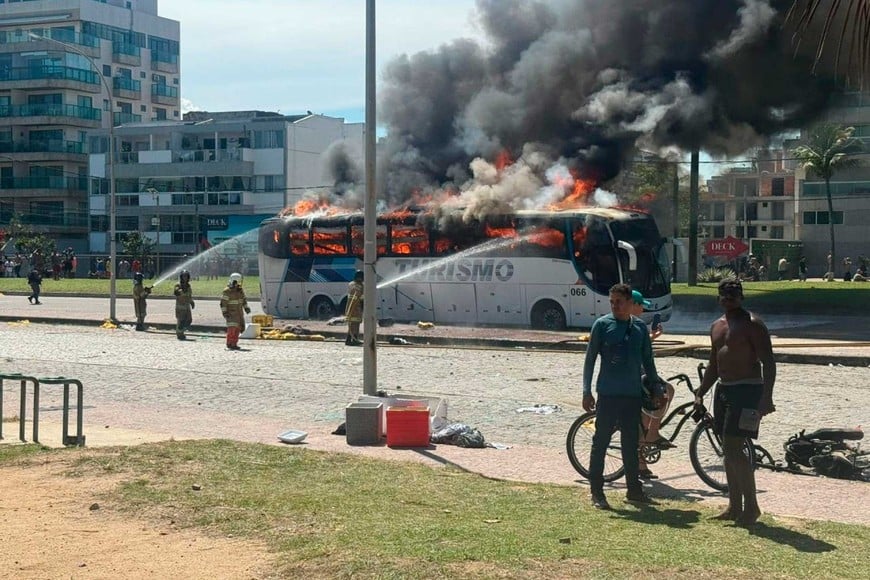 Bomberos brasileños apagan las llamas en un colectivo asediado. Foto: O Día