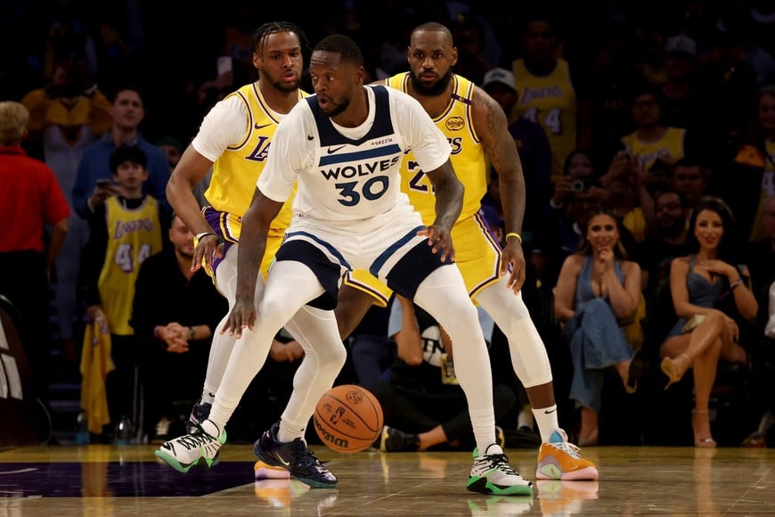 Oct 22, 2024; Los Angeles, California, USA; Los Angeles Lakers guard Bronny James (9) and forward LeBron James (23) guard Minnesota Timberwolves forward Julius Randle (30) during the second quarter against the Minnesota Timberwolves at Crypto.com Arena. This marked the first time in NBA history that a father and son played together. Mandatory Credit: Jason Parkhurst-Imagn Images     TPX IMAGES OF THE DAY