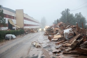 A car drives past damaged items from a furniture factory affected by torrential rains that caused flooding in La Alcudia, Valencia region, Spain, October 30, 2024. REUTERS/Eva Manez