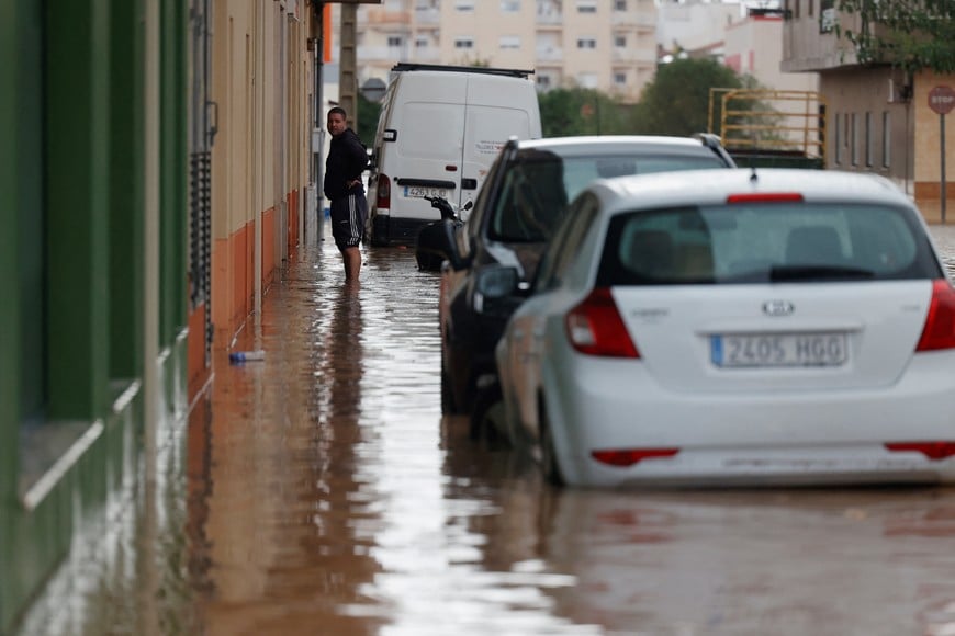 A person stands in a flooded street after the Spanish meteorological agency put the Valencia region in the highest red alert for extreme rainfalls, in Catadau, Valencia, Spain, October 29, 2024. REUTERS/Eva Manez