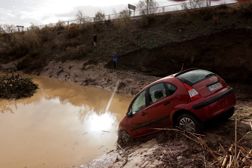 People stand in a flooded area after heavy rains and floods in Alora, Spain October 29, 2024. REUTERS/Jon Nazca